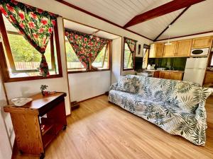 a living room with a couch and a kitchen at Faré tropical atiha in Tuarea