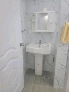 Baño blanco con lavabo y espejo en Obynb en Santo Domingo