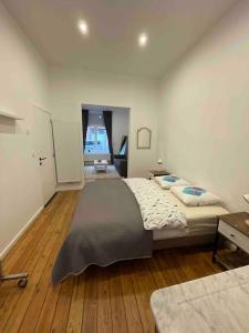 1 dormitorio grande con 1 cama grande y suelo de madera en studio indépendant sans cuisine - Le coin cosy avec WIFI, en Bruselas