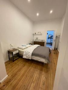 - une chambre avec un lit et du parquet dans l'établissement studio indépendant sans cuisine - Le coin cosy avec WIFI, à Bruxelles