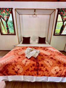 a bedroom with a bed with two towels on it at Faré tropical atiha in Tuarea