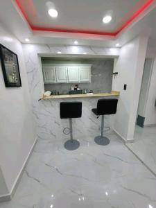 a kitchen with two stools in front of a counter at Obynb in Santo Domingo