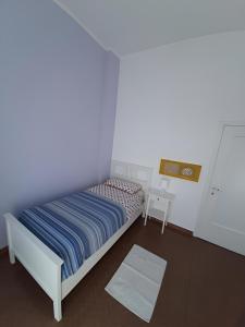 ein kleines Schlafzimmer mit einem Bett und einer weißen Wand in der Unterkunft Il Cortile in Brugherio