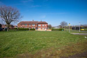 a large grassy field in front of a brick house at Starview Apartment-Manchester Airport in Manchester