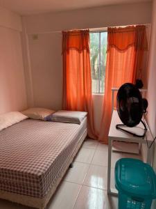 een slaapkamer met een bed en een raam met oranje gordijnen bij APTO NOVO E COMPLETO em OLINDA in Olinda