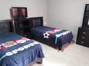 a bedroom with two beds with a soccer ball on them at Casa muy espaciosa y cómoda in Delicias