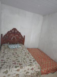 a bedroom with a bed with a comforter on it at Mini Chácara Cristo Redentor in Marechal Deodoro
