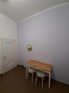 um quarto com uma mesa e duas cadeiras e uma porta em Il Cortile em Brugherio