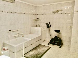 a bathroom with a tub and a vacuum in it at Spacious Roof Top Maisonett Apartment in PRIEN at Lake Chiemsee in Stock