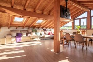 sala de estar con techos de madera, mesa y sillas en Casa Garabeto, en Luanco