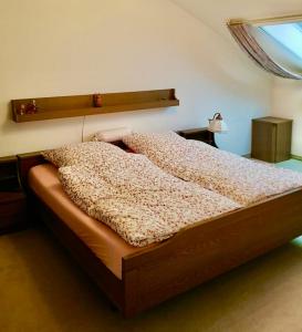 a bed with a wooden headboard in a bedroom at Spacious Roof Top Maisonett Apartment in PRIEN at Lake Chiemsee in Stock