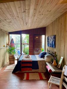 a bedroom with a large bed and a wooden ceiling at CASA JANE in Imbituba