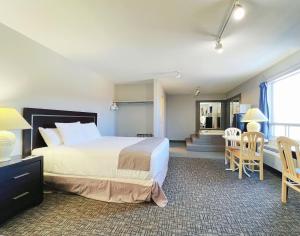 una camera d'albergo con letto, tavolo e sedie di Riverside Inn a Wabasca