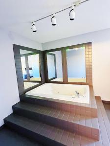 una vasca da bagno in una stanza con finestre di Riverside Inn a Wabasca