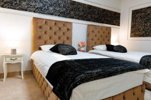 two beds in a hotel room with two beds sidx sidx sidx at Pensiunea Infinity in Târgu Jiu