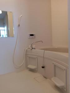 a white bathroom with a sink and a mirror at Tokyo downtown芍藥莊 in Tokyo