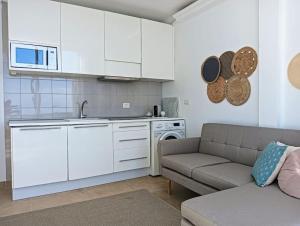 ein Wohnzimmer mit Couch und Küche in der Unterkunft Casa Martín in Puerto del Carmen