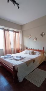 um quarto com uma cama grande e uma janela em Av España Mdz em Mendoza