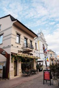 a building with a table in front of it at Pensiunea Infinity in Târgu Jiu