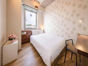 En eller flere senge i et værelse på Tokai City Hotel