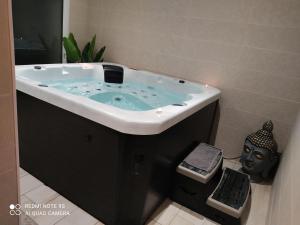 Gîtes des Colombières & Spa في Saint-Maixent-sur-Vie: حمام مع حوض استحمام مع قناع أسود