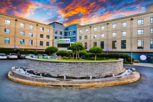 un edificio con una fontana di mattoni in un parcheggio di Holiday Inn Express Sandton-Woodmead, an IHG Hotel a Johannesburg