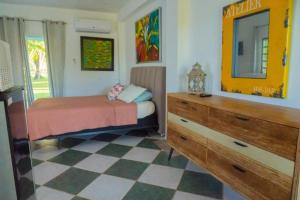 Schlafzimmer mit einem Bett, einer Kommode und einem Spiegel in der Unterkunft Casita Mami in Arecibo