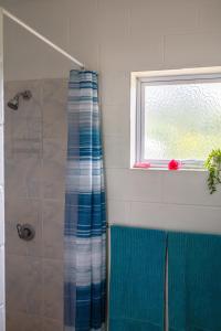 einen Duschvorhang im Bad mit Fenster in der Unterkunft Joseph Retreat in Avarua