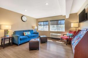 a living room with a blue couch and a clock at Comfort Inn Monterey Park - Los Angeles in Monterey Park