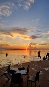 een groep mensen op het strand bij zonsondergang bij Tropical Executive ap 305 in Manaus
