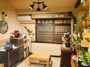 京都市にあるサンタナゲストハウス京都の鉢植えの植物と大きな窓が備わるお部屋