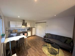 a living room and kitchen with a couch and a table at Modern 2 Bedroom Apartment near train station in Eichwäldchen