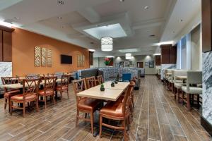 uma sala de jantar com mesas e cadeiras num restaurante em Drury Plaza Hotel Richmond em Glen Allen