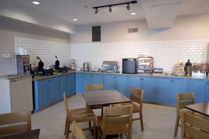 een keuken met blauwe kasten en een tafel en stoelen bij Country Inn & Suites by Radisson, Council Bluffs, IA in Council Bluffs