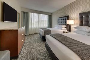 a hotel room with two beds and a flat screen tv at Drury Plaza Hotel Richmond in Glen Allen