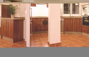 kuchnia z drewnianymi szafkami i podłogą wyłożoną kafelkami w obiekcie Pet Friendly Apartment w mieście Fuengirola