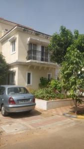 a car parked in a parking lot in front of a house at Gardenia Groove Villa, Ramky Discovery City in Maisaram