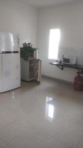 eine leere Küche mit einem Kühlschrank und einer Mikrowelle in der Unterkunft Gardenia Groove Villa, Ramky Discovery City in Maisaram