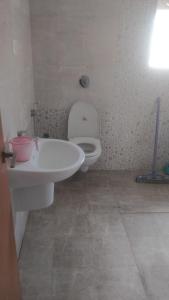 ein Badezimmer mit einem weißen WC und einem Waschbecken in der Unterkunft Gardenia Groove Villa, Ramky Discovery City in Maisaram