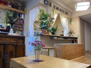 a room with a table with a vase of flowers on it at Santana Guest House Kyoto in Kyoto