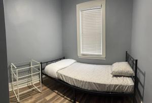 - une petite chambre avec un lit et une fenêtre dans l'établissement Urban Retreat 3 Bedroom Apt., à Chicago