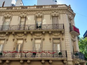 ein hohes Gebäude mit Balkonen und Blumen darauf in der Unterkunft Hotel europeo in Buenos Aires