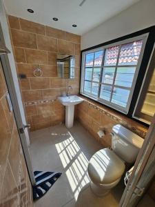 ein Bad mit einem WC, einem Waschbecken und einem Fenster in der Unterkunft Penthouse con Jacuzzy en Santo Domingo in Cancino