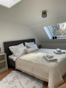 a white bedroom with a large bed with a window at İnci in Hamburg