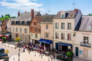 Un gruppo di persone che camminano per strada in una città di Home de Vitruve a Amboise