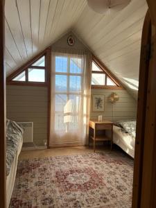 a attic room with two beds and a window at Sveggvika Atlantic Home in Averoy
