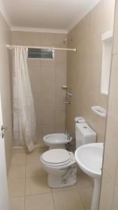 a white bathroom with a toilet and a sink at Departamento Jorge in Marcos Juárez