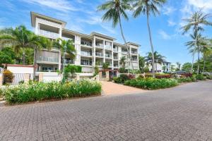 una strada vuota di fronte a un edificio con palme di Turquesa Tides - Beachfront Resort Living a Palm Cove