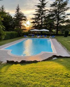 een zwembad in een tuin met stoelen en parasols bij Villa Carla Piemonte private pool in Melazzo