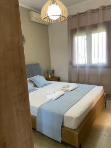 a bedroom with a large bed with towels on it at Apartment Nina Holidays in Paralia Sikias